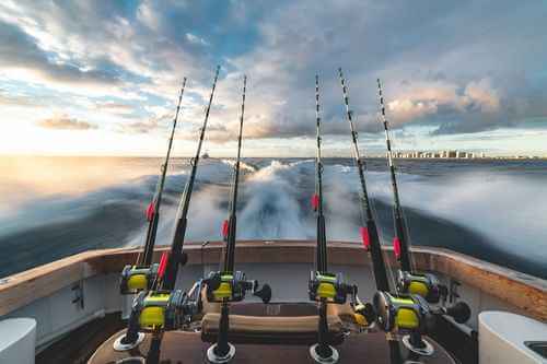Family fishing from a boat during a Fishing Club Canada summer camp on a Canadian lake