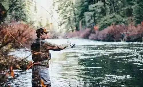 Canadian angler proudly holding a northern pike for a photo