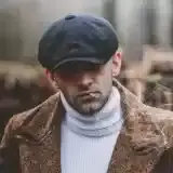 Member Jerome Bell holding a trout in a net on a clear river