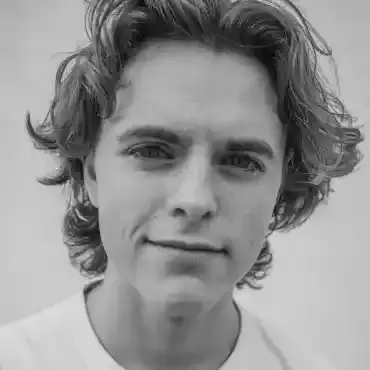 Jerome Bell lifting a tournament cup in front of a Canadian lake